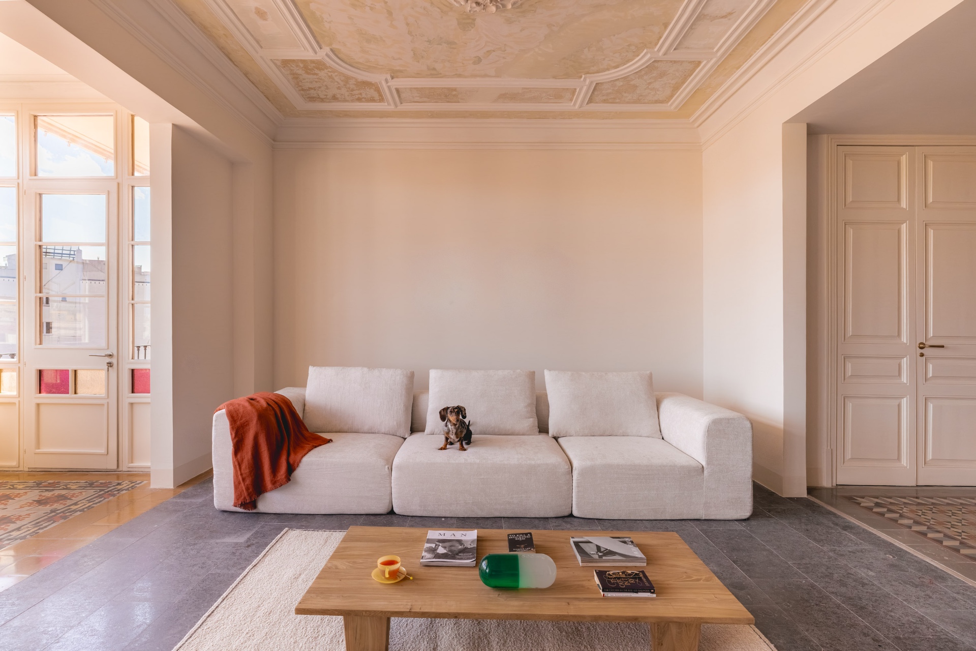 A curated interior, sculptural seating and a single artwork in soft daylight.